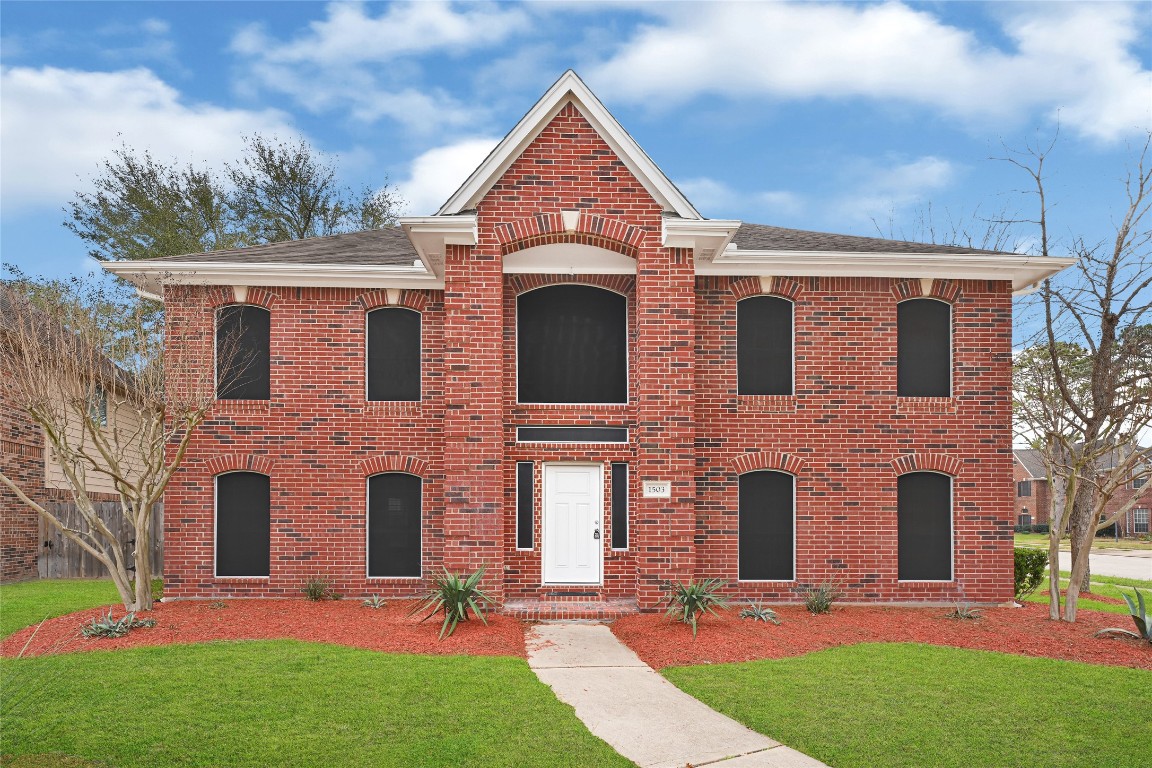 a front view of a house with a garden and plants