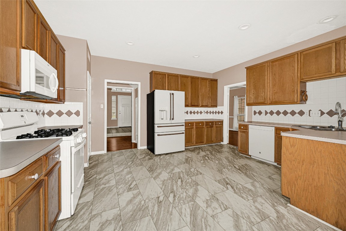 1503 Pine Ridge Lane Pearland, TX 77581 - Photo 11 of 23 a kitchen with stainless steel appliances granite countertop a stove top oven a refrigerator a stove with white cabinets