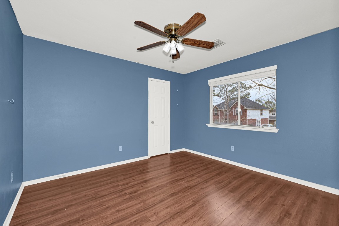 1503 Pine Ridge Lane Pearland, TX 77581 - Photo 14 of 23 an empty room with wooden floor and ceiling fan