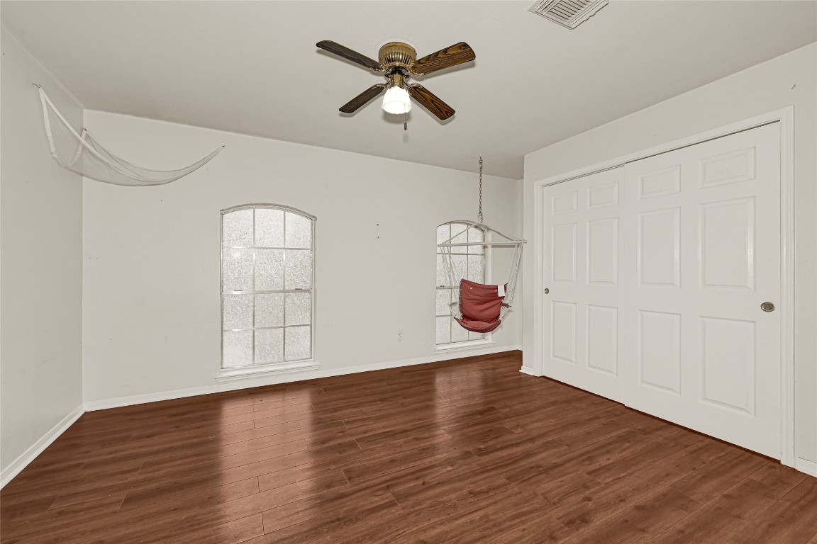 1503 Pine Ridge Lane Pearland, TX 77581 - Photo 17 of 23 an empty room with wooden floor chandelier fan and windows