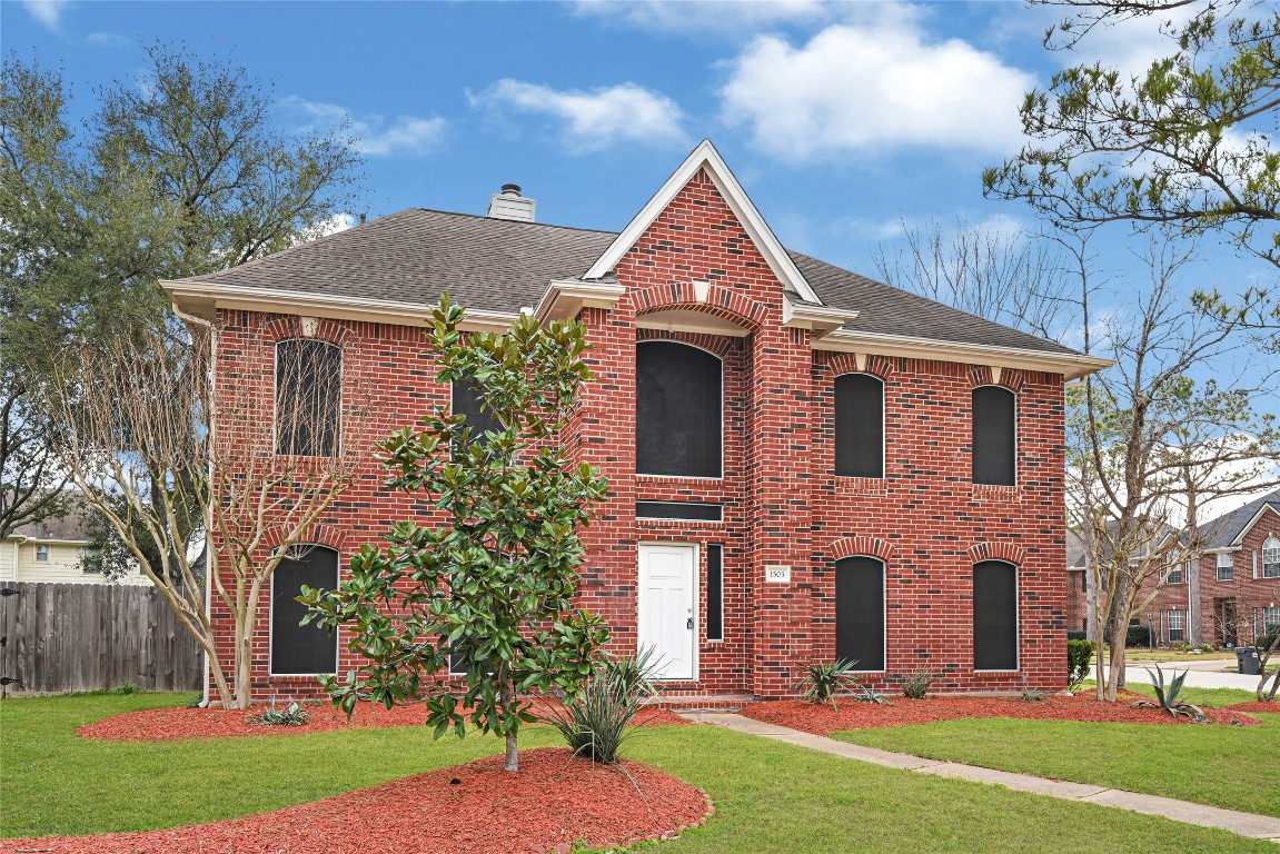 1503 Pine Ridge Lane Pearland, TX 77581 - Photo 2 of 23 a front view of a house with a yard
