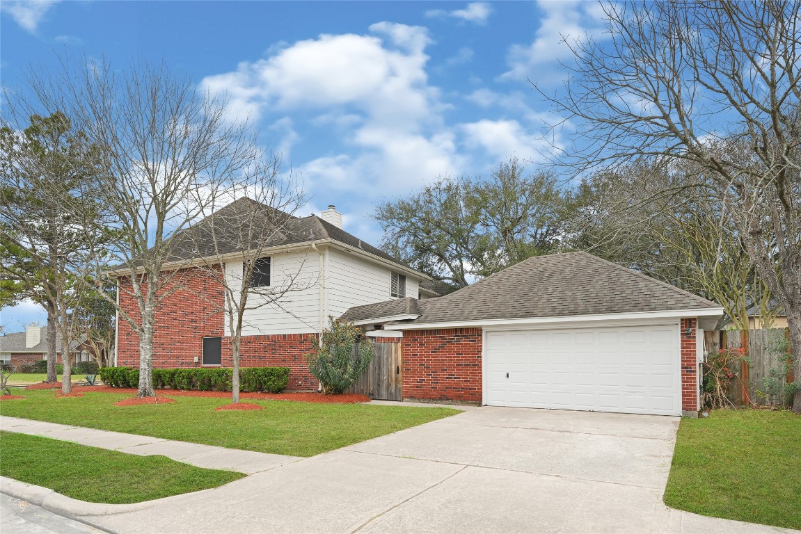 1503 Pine Ridge Lane Pearland, TX 77581 - Photo 3 of 23 a front view of a house with a yard and garage