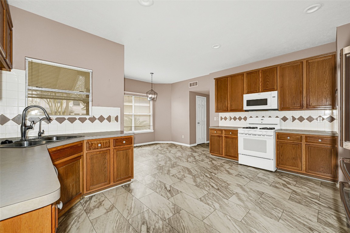1503 Pine Ridge Lane Pearland, TX 77581 - Photo 9 of 23 a large kitchen with granite countertop a sink stainless steel appliances and cabinets