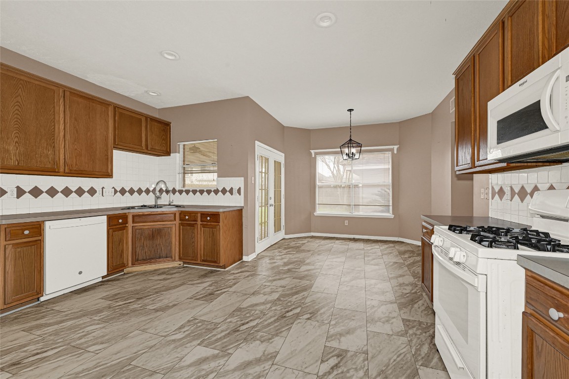 1503 Pine Ridge Lane Pearland, TX 77581 - Photo 10 of 23 a kitchen with stainless steel appliances a stove and white cabinets
