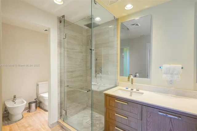 a bathroom with a sink a toilet and shower