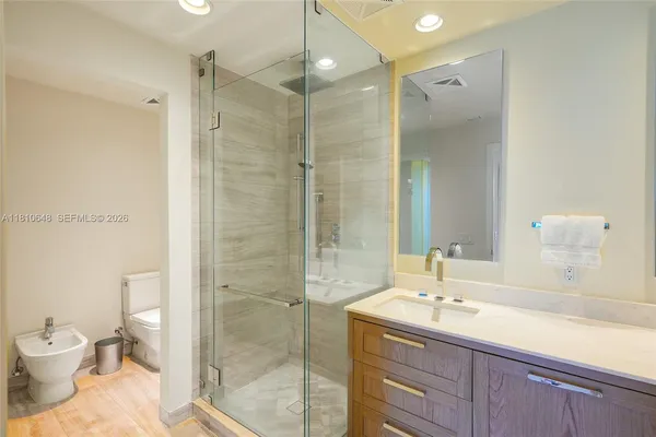 a bathroom with a sink a toilet and shower