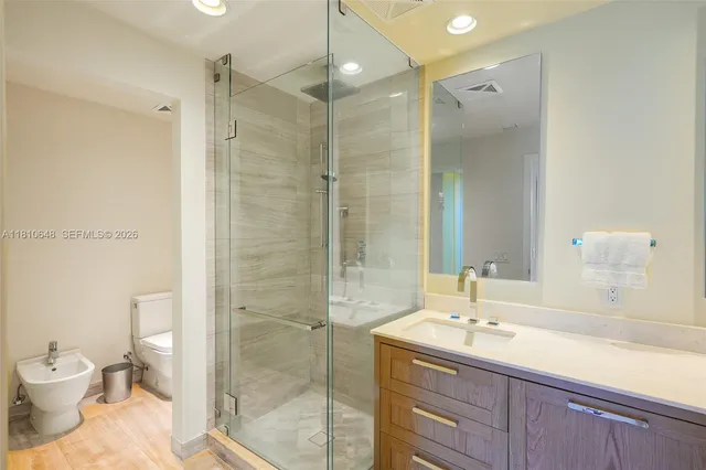 a bathroom with a sink a toilet and shower