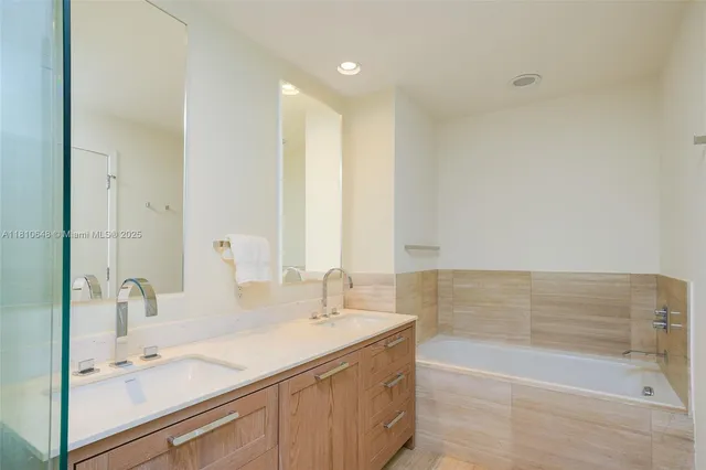 a bathroom with a tub sink and mirror