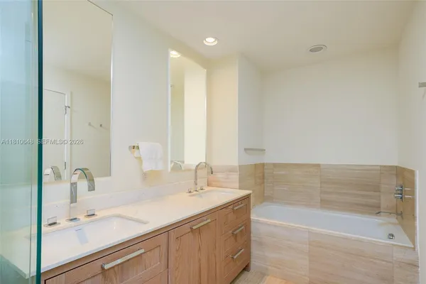 a bathroom with a tub sink and mirror