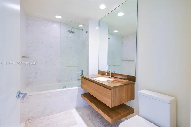 a spacious bathroom with a tub sink and mirror
