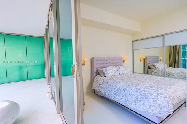 a bedroom with a bed and a dresser next to a window