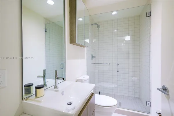 a bathroom with a sink a toilet and shower