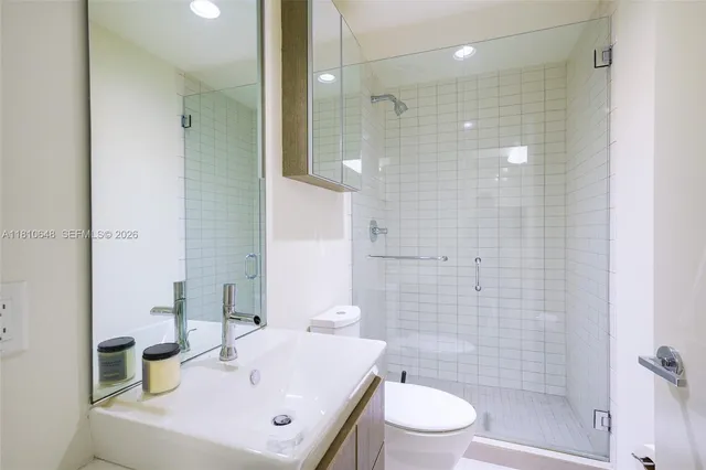 a bathroom with a sink a toilet and shower