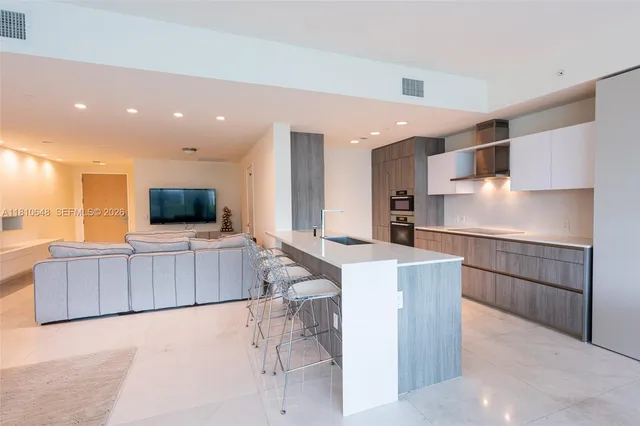 a kitchen with stainless steel appliances kitchen island granite countertop a refrigerator and a stove top oven