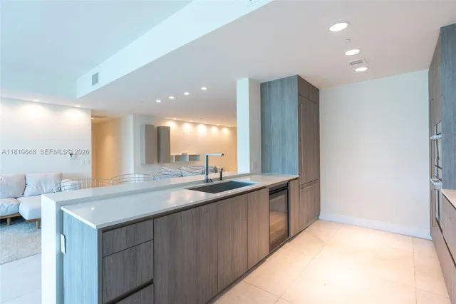 a kitchen with stainless steel appliances granite countertop a sink and a large mirror