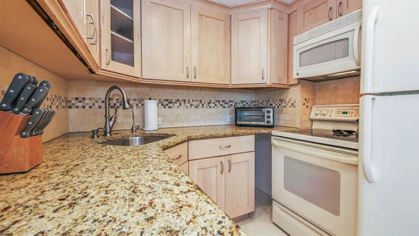 a kitchen with stainless steel appliances granite countertop a refrigerator and a sink
