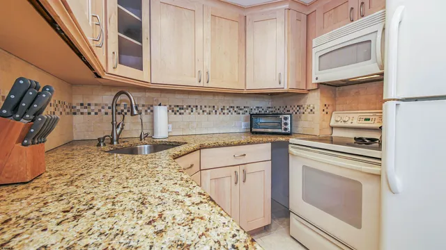 a kitchen with stainless steel appliances granite countertop a refrigerator and a sink