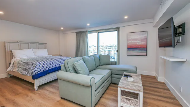 a spacious bedroom with a bed and wooden floor