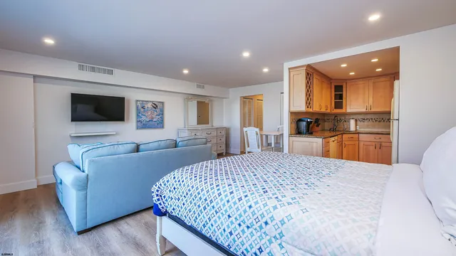 a large bedroom with bed and wooden floor