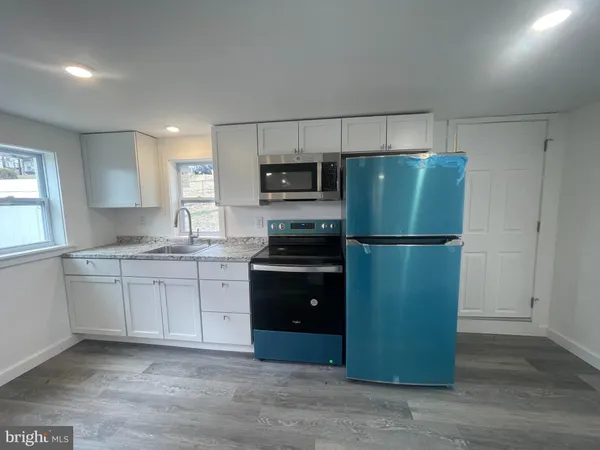 a kitchen with granite countertop a refrigerator and a sink