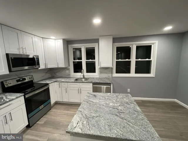a kitchen with granite countertop wooden cabinets and stainless steel appliances