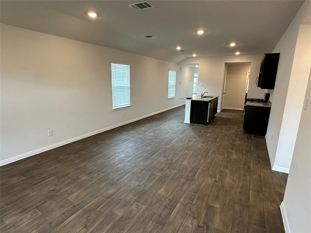 563 Evergreen Sumac Loop Kyle, TX 78640 - Photo 18 of 18 An open floorplan seamlessly connects the living and kitchen areas, illuminated by recessed lighting.