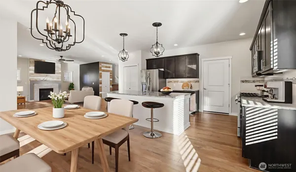 a view of a dining room with furniture a kitchen and chandelier