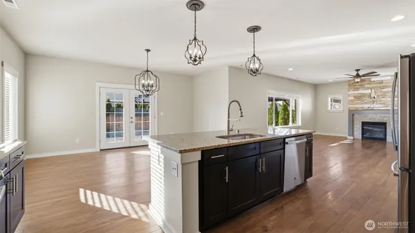 a view of a kitchen counter space a sink wooden floor and windows