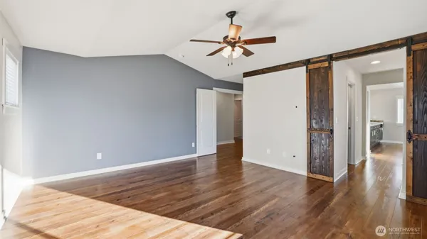 a view of a room with wooden floor and ceiling fan