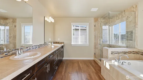 a bathroom with a granite countertop sink a large mirror and a bathtub