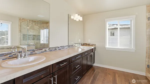 a bathroom with a granite countertop sink a large mirror and a bathtub