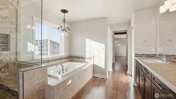 a spacious bathroom with a granite countertop tub sink and mirror