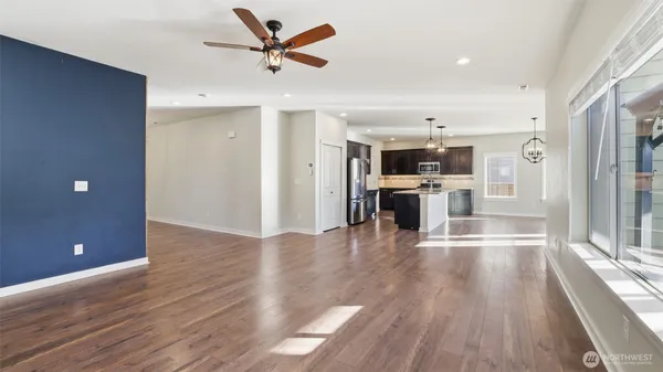 a view of a big room with wooden floor and a kitchen