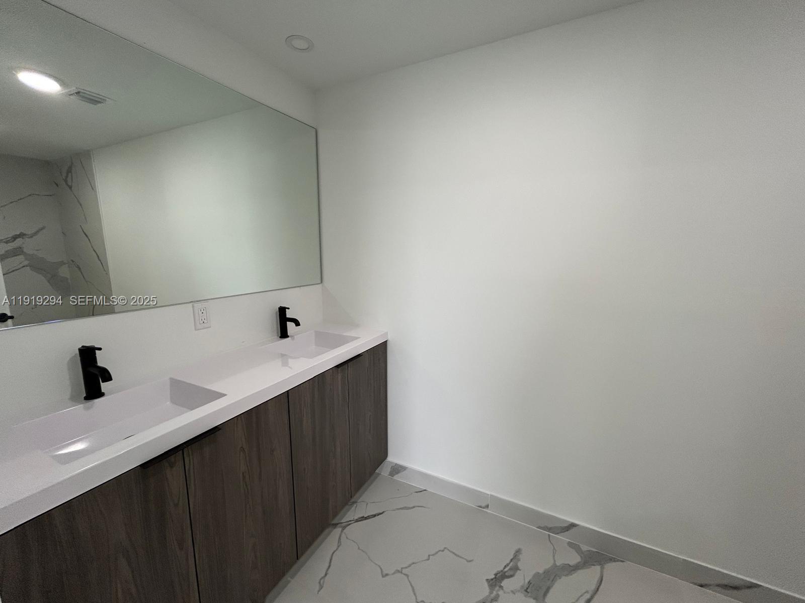 14568 Southwest 261st Terrace, Unit 2 Homestead, FL 33032 - Photo 12 of 22 a bathroom with a double vanity sink and mirror