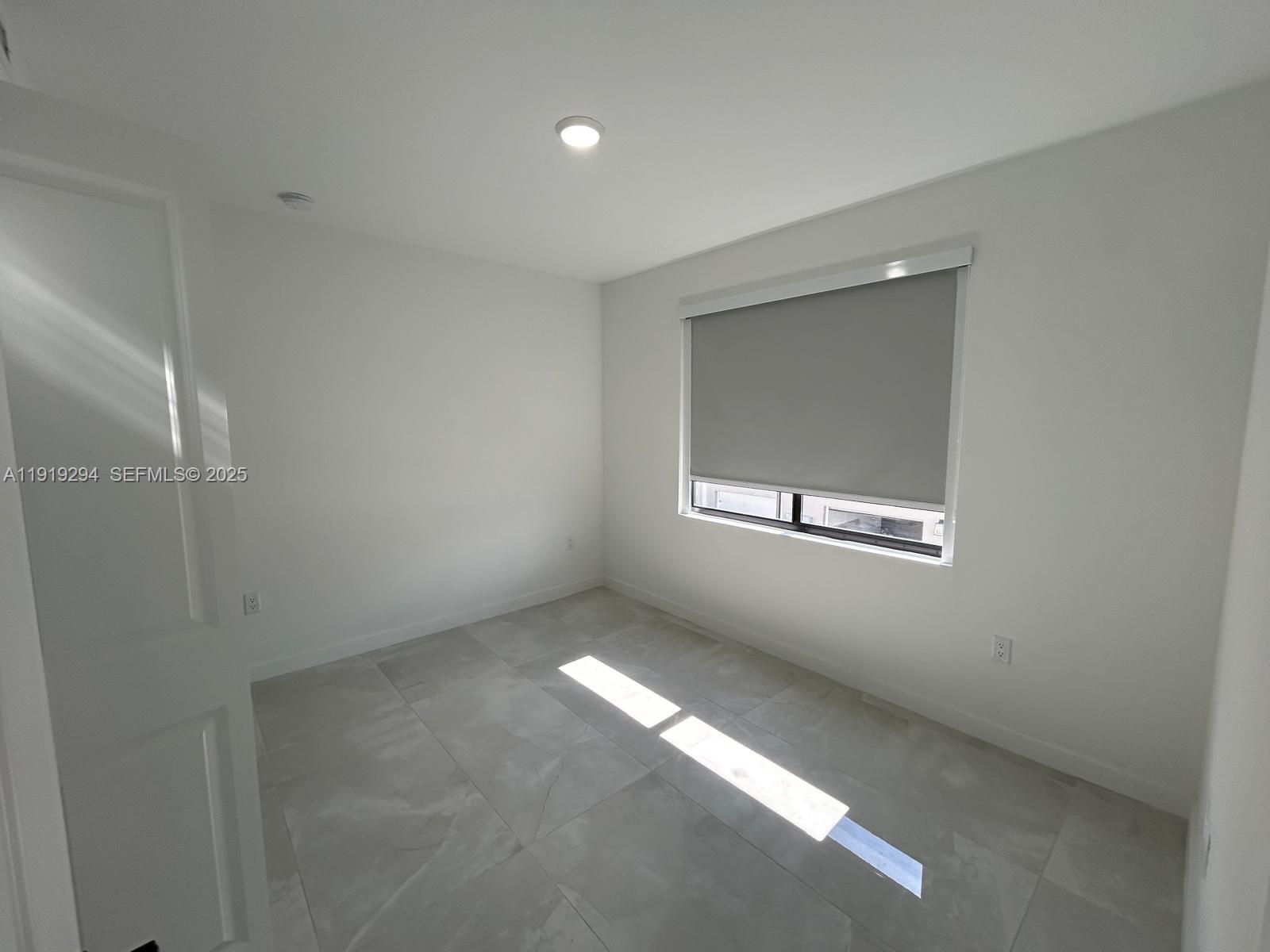 14568 Southwest 261st Terrace, Unit 2 Homestead, FL 33032 - Photo 14 of 22 a view of an empty room with a window