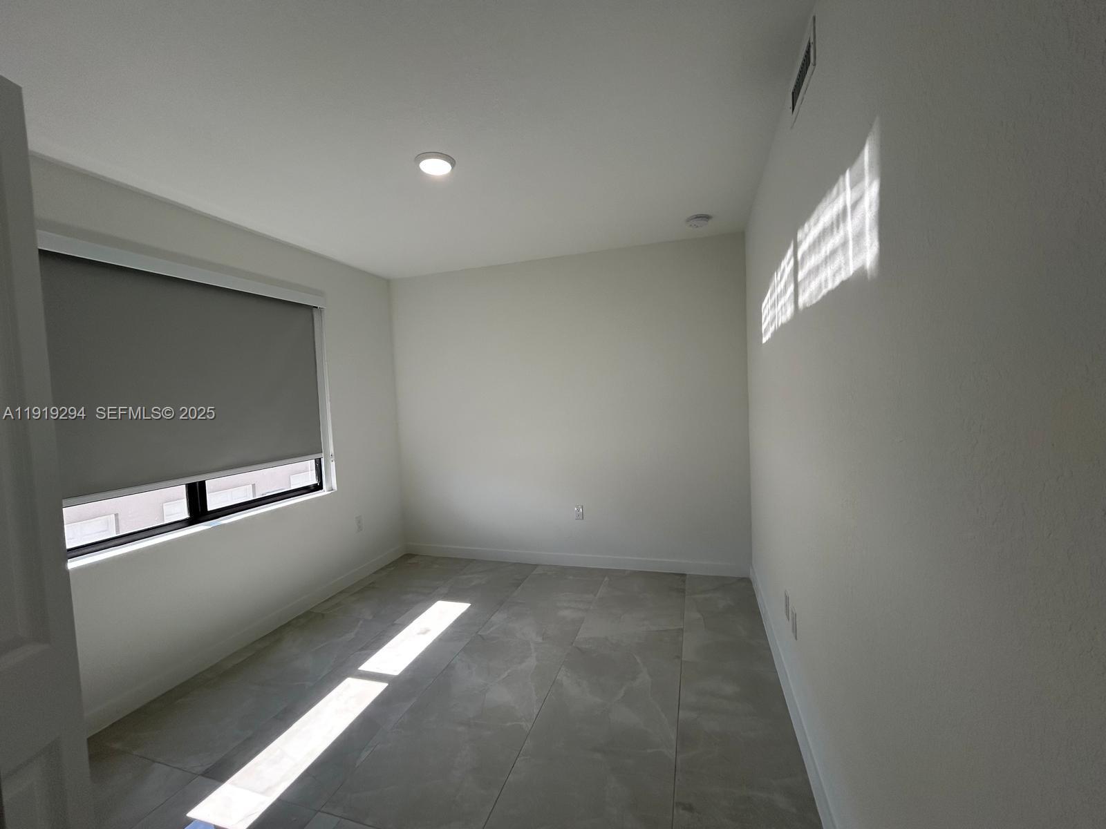 14568 Southwest 261st Terrace, Unit 2 Homestead, FL 33032 - Photo 18 of 22 an empty room with windows