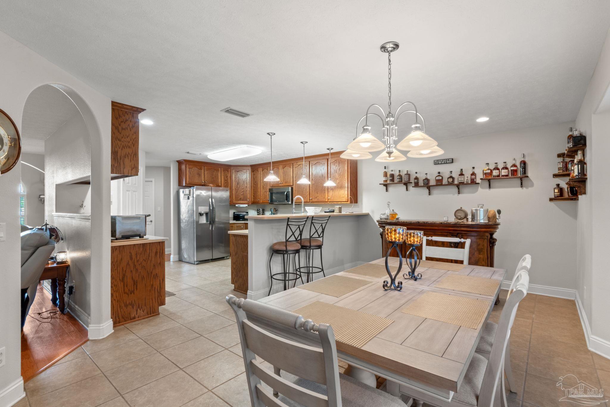 4381 Molino Road Molino, FL 32577 - Photo 18 of 72 a view of a dining room and livingroom with furniture wooden floor a rug a fireplace and a chandelier