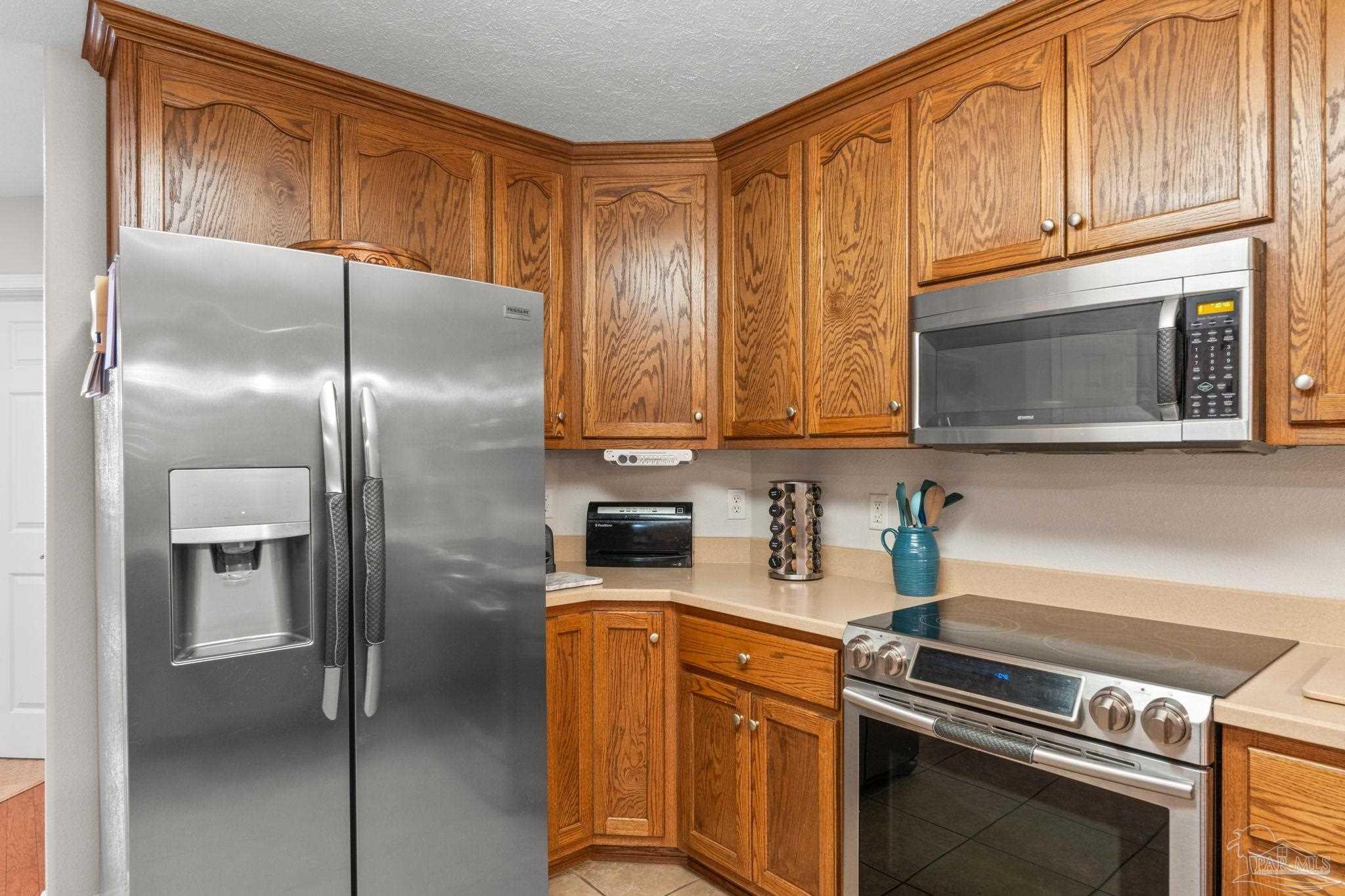 4381 Molino Road Molino, FL 32577 - Photo 21 of 72 a kitchen with stainless steel appliances granite countertop a refrigerator a stove and a sink with wooden floor