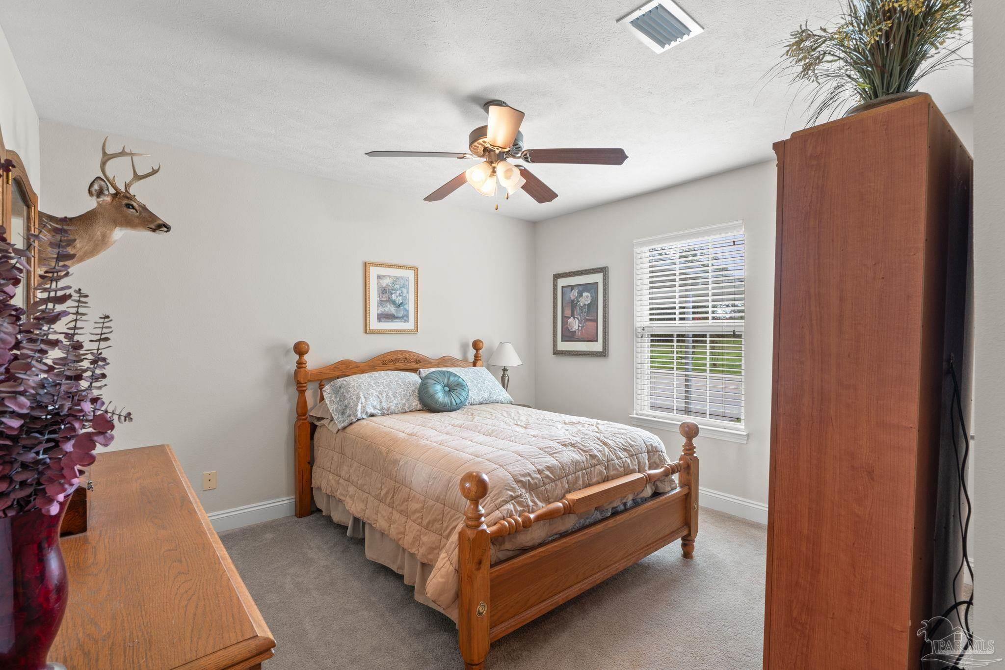 4381 Molino Road Molino, FL 32577 - Photo 26 of 72 a bedroom with a bed and a chandelier