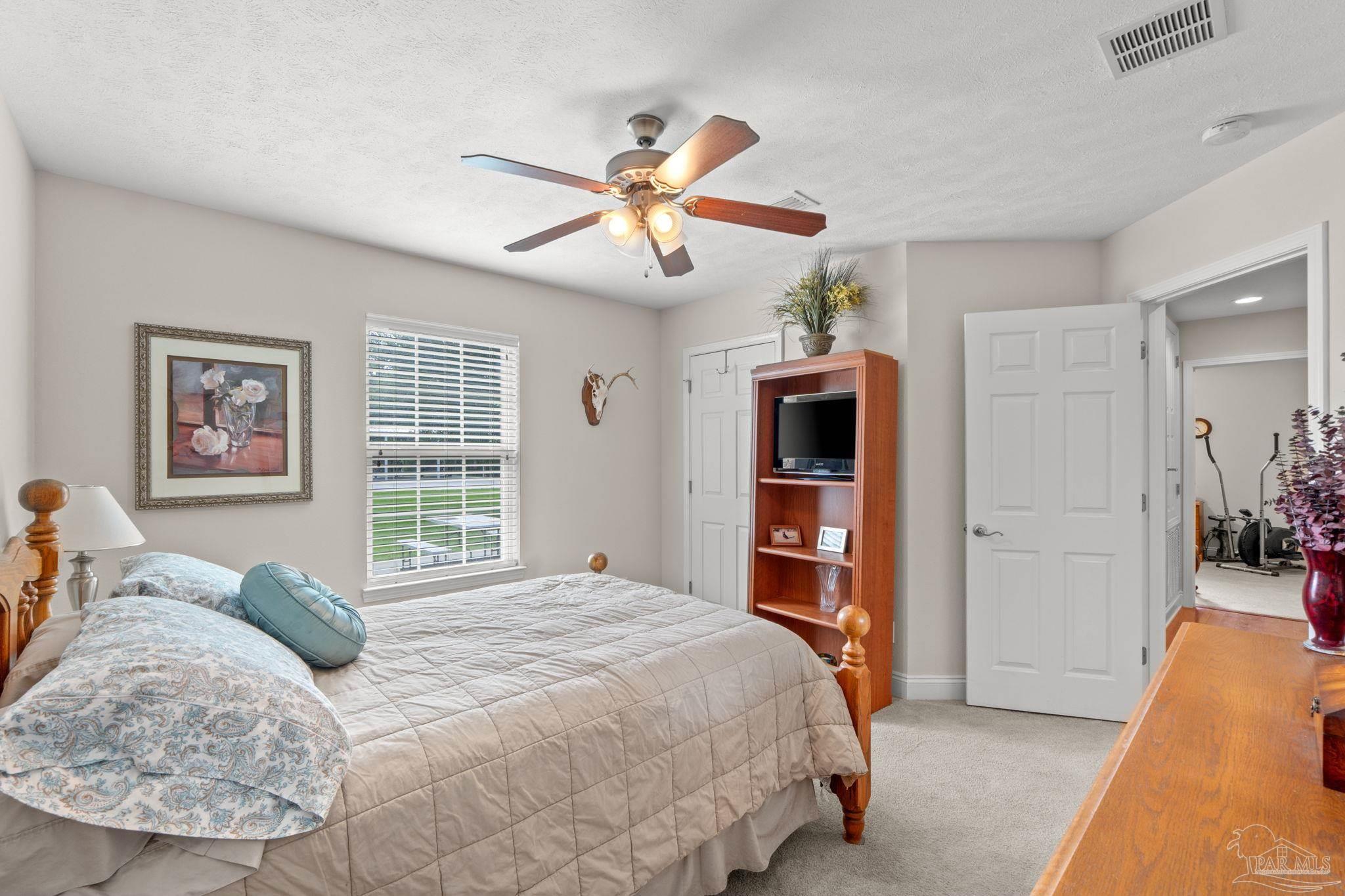 4381 Molino Road Molino, FL 32577 - Photo 27 of 72 a bedroom with a large bed and a chandelier
