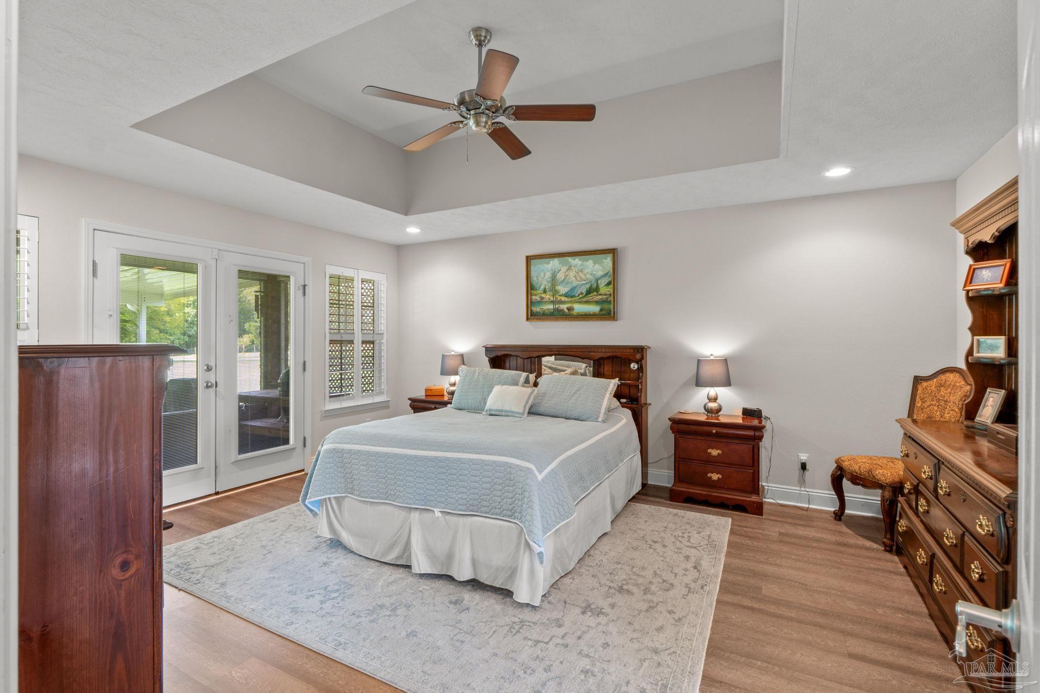 4381 Molino Road Molino, FL 32577 - Photo 30 of 72 a spacious bedroom with a large bed and a chandelier