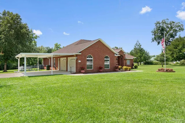 a front view of a house with yard and green space