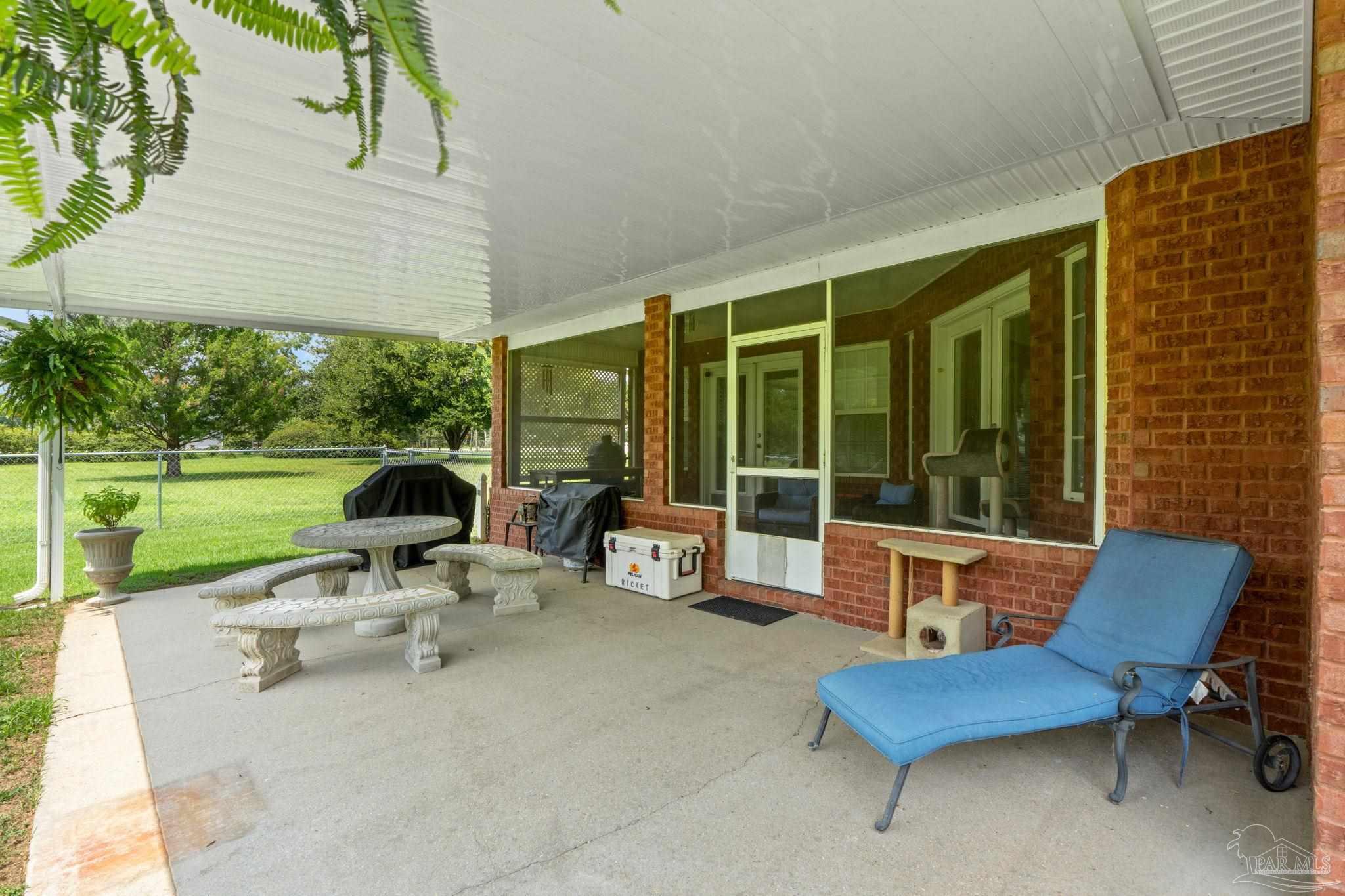 4381 Molino Road Molino, FL 32577 - Photo 40 of 72 a view of a patio with a table chairs and a backyard
