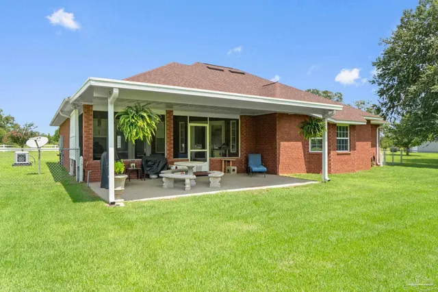 a view of a house with a yard and a large tree
