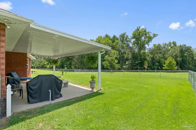 a backyard of a house with plants and large trees
