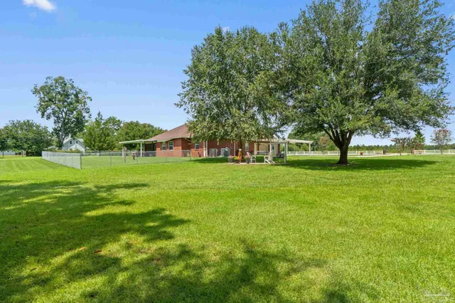an aerial view of a house with swimming pool and yard