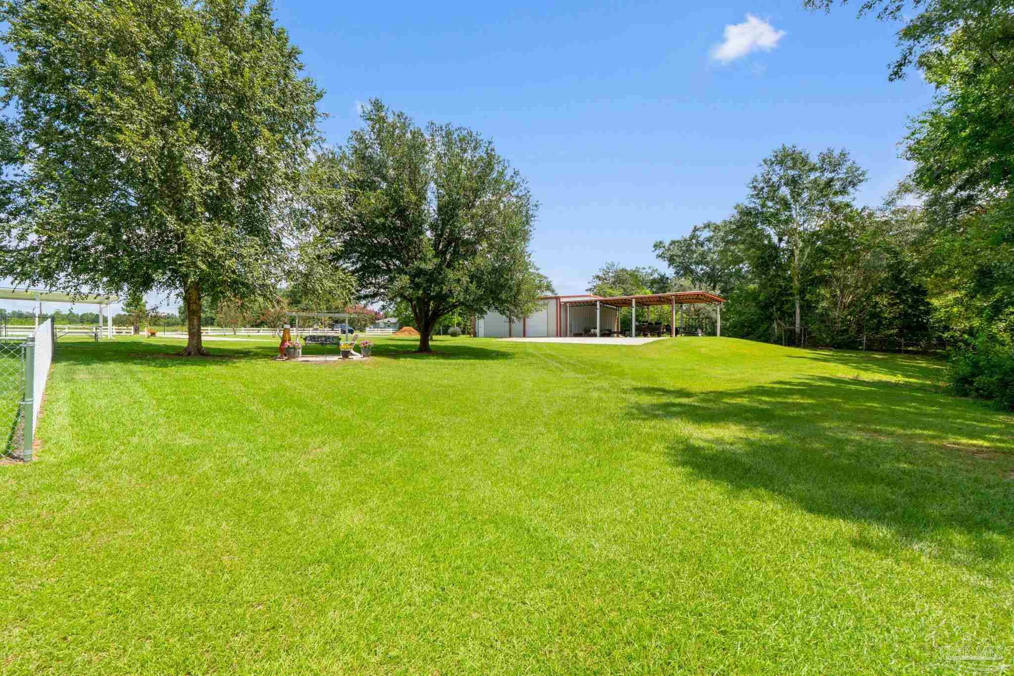 4381 Molino Road Molino, FL 32577 - Photo 56 of 72 a view of a grassy field with trees in the background