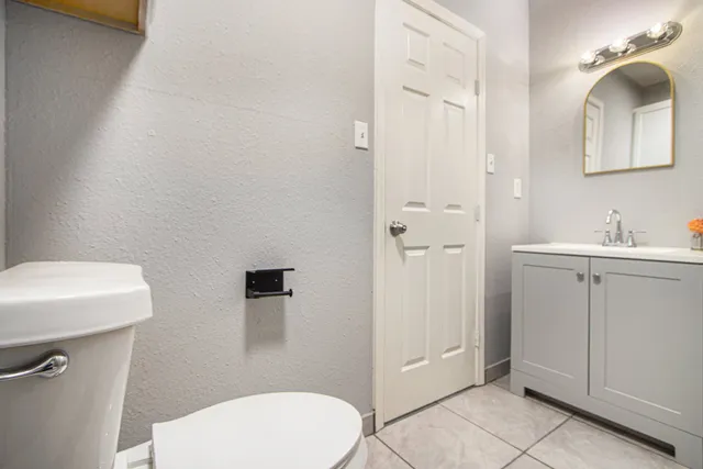 an empty room with chandelier fan and windows