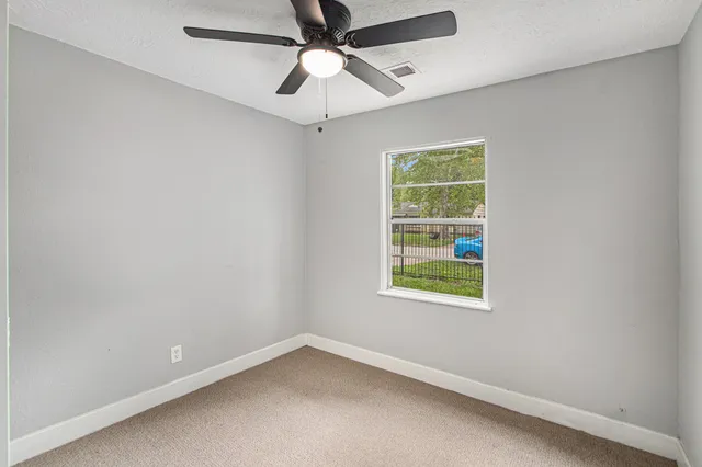 an empty room with chandelier fan
