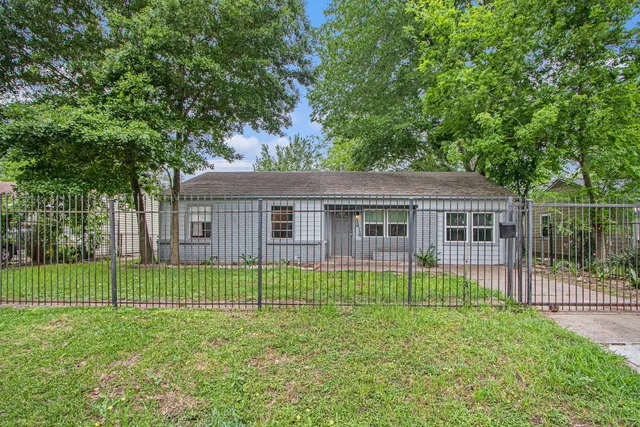 a view of a house with a backyard and a tree